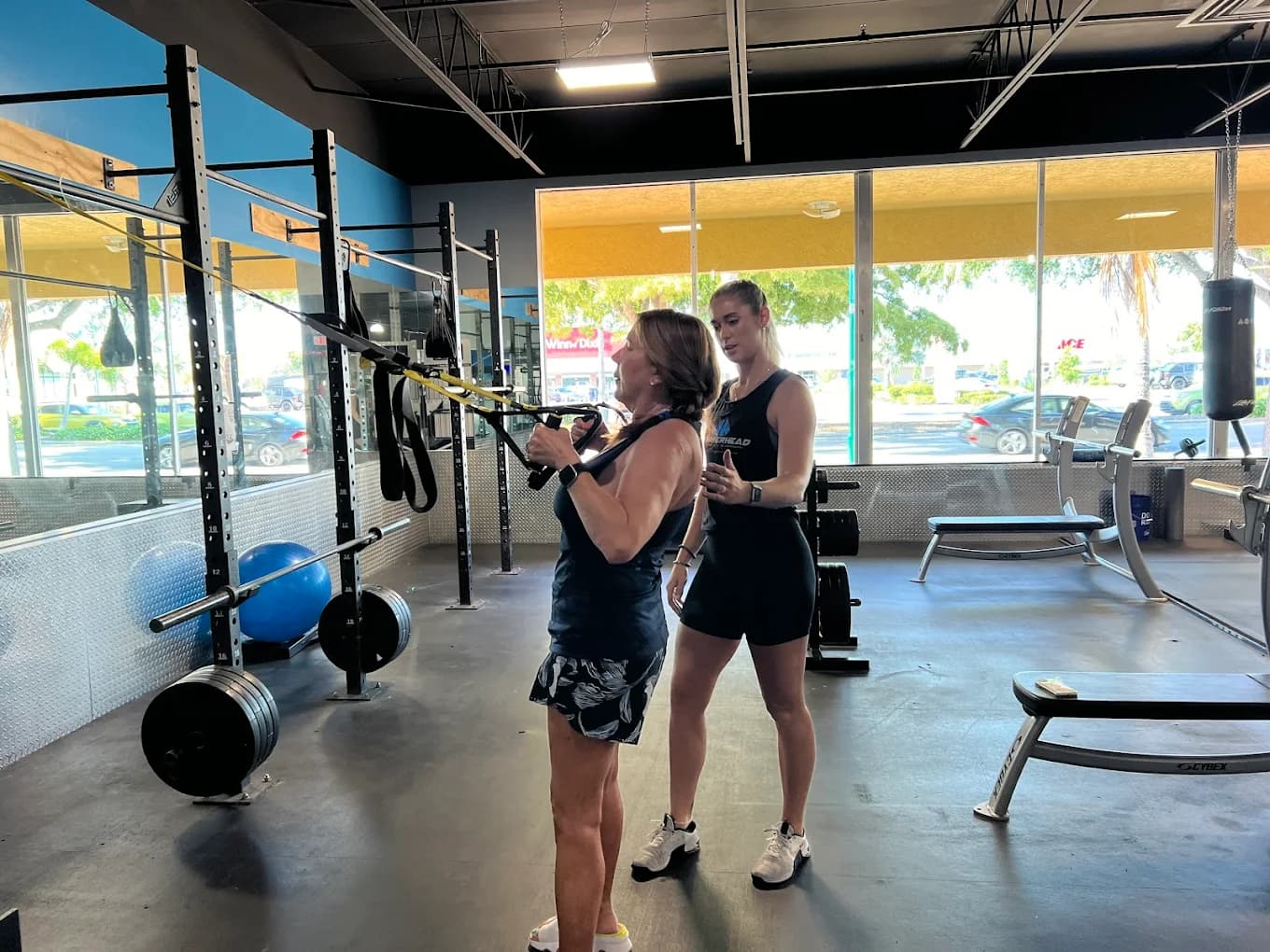 A Hammerhead coach working one-on-one with a member on suspension training.
