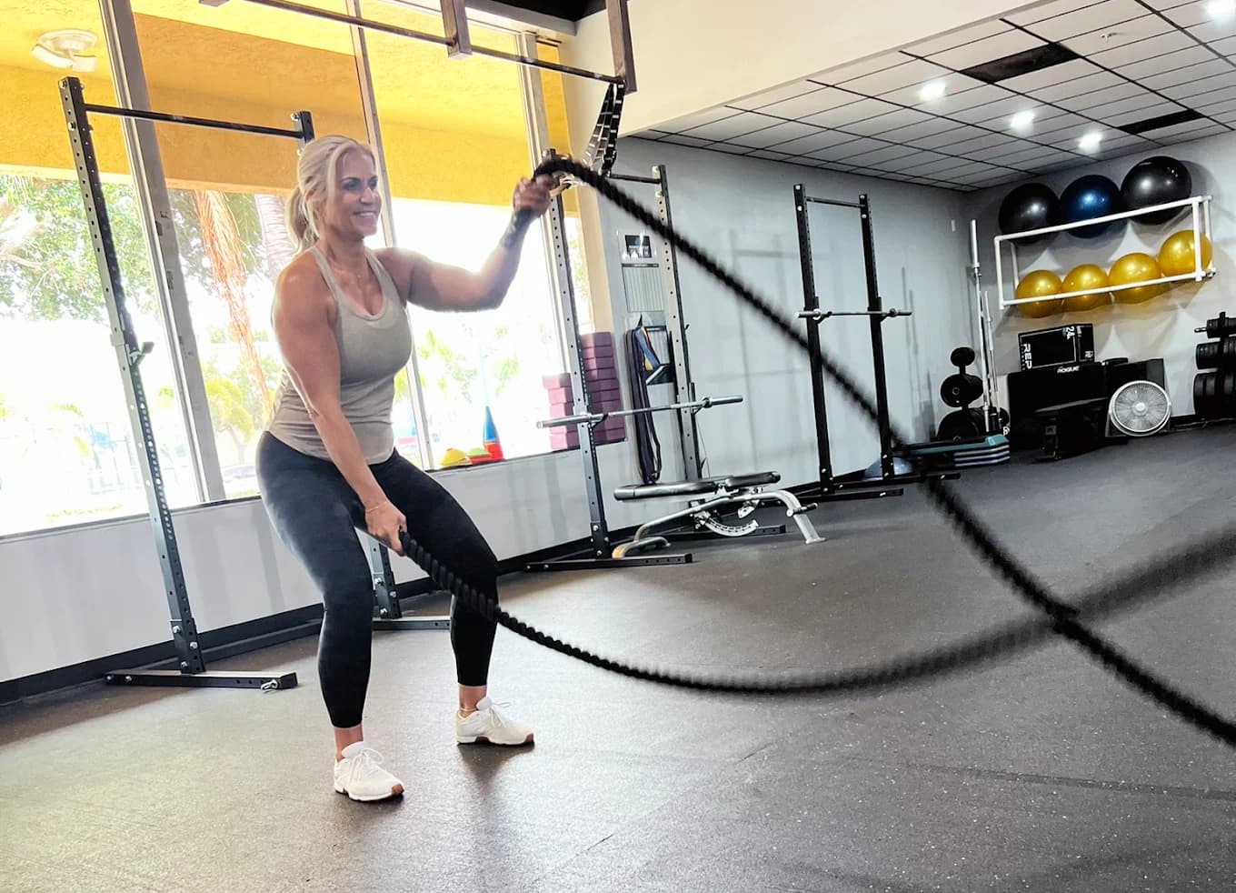 A member training with battle ropes on the bright Hammerhead Gym floor in Cape Coral.
