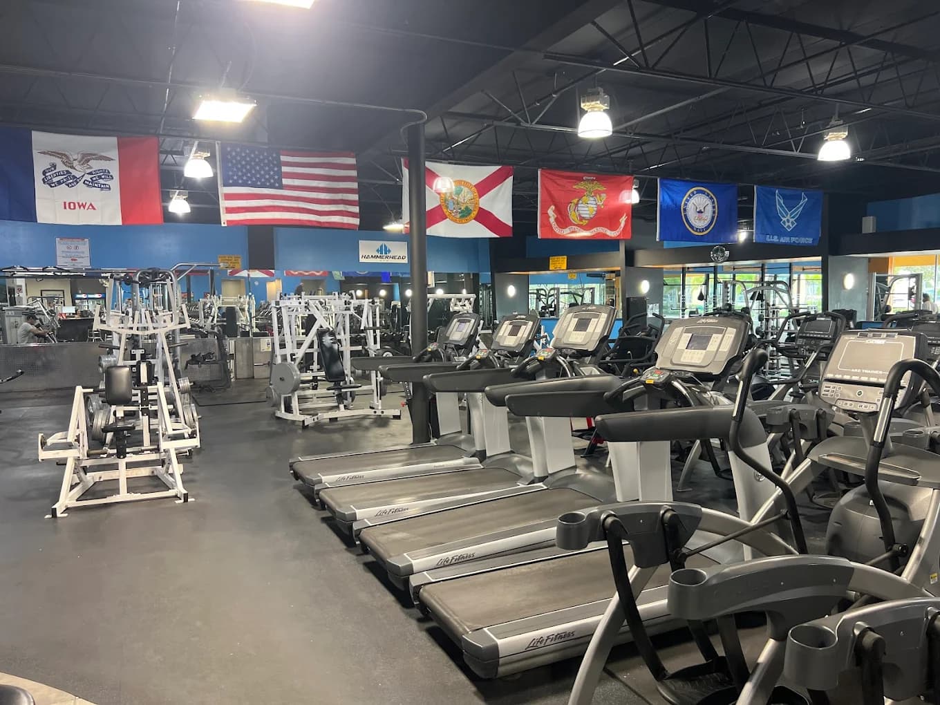 The Hammerhead Gym training floor with U.S. and military service flags above the cardio area.